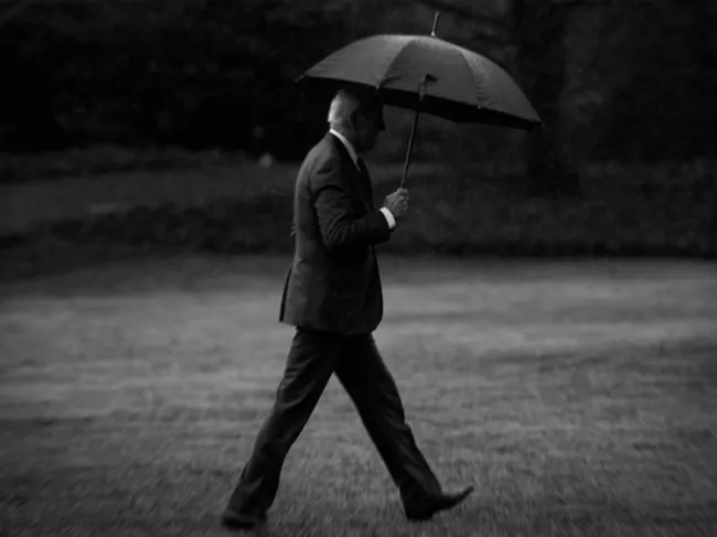 Joe Biden walks with an umbrella